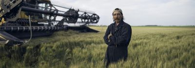 Hombre en un campo cerca de una trilladora